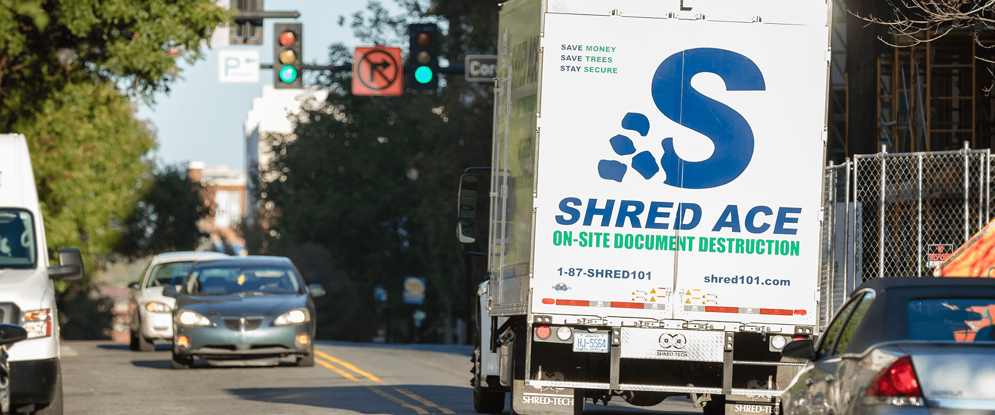 shred-ace-truck-in-street-with-cars-min
